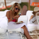 Supermodel Natasha Poly in a pink bandeau bikini at the beach in Miami