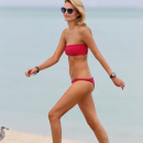Supermodel Natasha Poly in a pink bandeau bikini at the beach in Miami