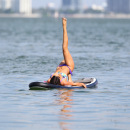 Claudia Romani paddleboarding in a thong bikini in Miami