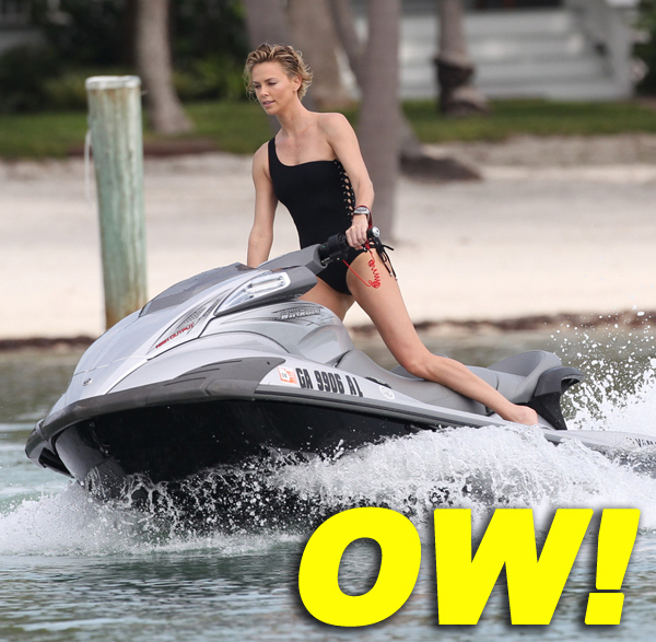 Charlize Theron wears a black one piece bikini as she hits the waves on a jet ski in Miami